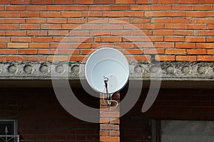Close-up of a house wall with solar panels and satellite dish with antenna TV