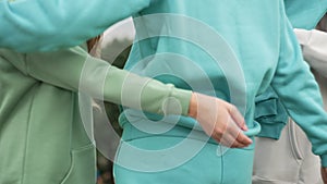 A close-up how the hands of the daughter and granddaughter embrace grandmother