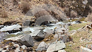 Close-up of how a mountain river flows. Beautiful view of the purest mountain cold stream with clear water.