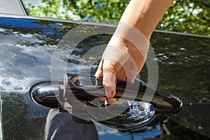 Close up of human child hand opening car door