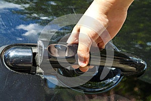 Close up of human child hand opening car door