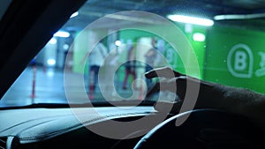 Close-up of a human hand on a car dashboard, while waiting in a closed parking in a supermarket. 4k, slow motion