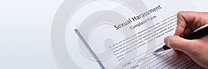 Human Hand Filling Sexual Harassment Complaint Form