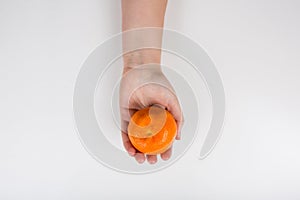 Close up of a human hand holding an fresh orange tangerine or clementine isolated on white background with copy space. Bio