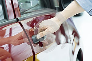 Close up of human hand opening door of car.