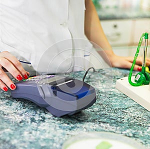 Close up of human hand over payment machine in drug store