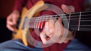 Close up of human hand is playing guitar