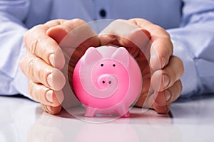 Human Hand Protecting Piggy Bank