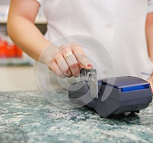 Close up of human hand putting credit card into payment machine