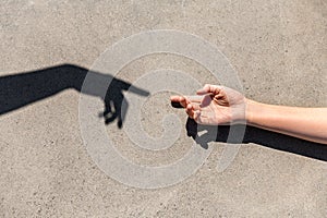 close up of human hand reaching to shadow