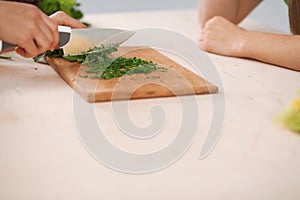 Close-up of human hands cooking vegetables salad in kitchen. Healthy meal and vegetarian concept