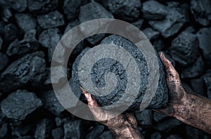 Close up of human hands holding coal