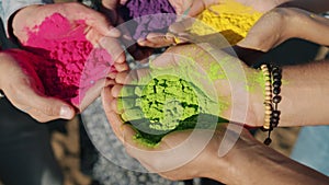 Close-up of human hands holding colorful powder paint gulal for Holi festival ceremony outside