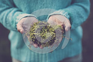 Close up of human hands holding natural green musk. Concept of earth`s day and stop climate change. Global warming bad future.