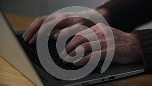 Close up human hands are typing notebook keyboard. Creative copywriter texting to his employer using laptop. Data