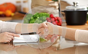 Close-up of human handshake. Two women in kitchen shaking hands to each other. Cooking, friendship or family fun