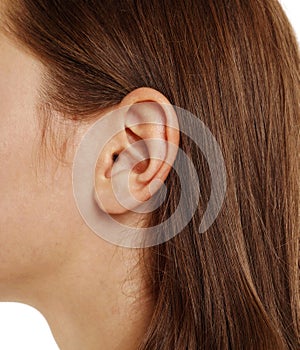 Close up human woman`s ear over white background