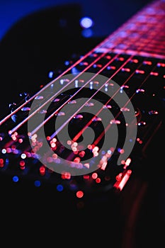 Close-up of a humbucker. Detail of six-string electric guitar, soft selective focus. With colorful blue and purple illumina