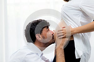 Close up husband kiss pregnant woman belly