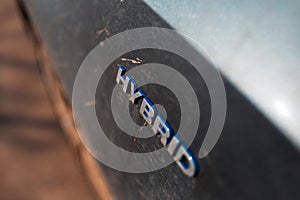 Close-up of Hybrid icon on dirty car body. Environment concept. Ecological transport