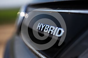 Close up of the hybrid sign dark grey car