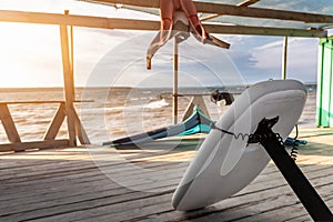 Close-up hydrofoil surf board kite equipment on wooden pier jetty shore watersport spot bright sunny day against sea