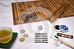 Close up of an I Ching arrangement with a handwritten Hexagram and different utensils