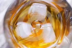 Close up of ice in glass of alcohol or whiskey