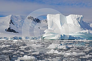 Close up of iceberg shaped by water surrounded by melting ice