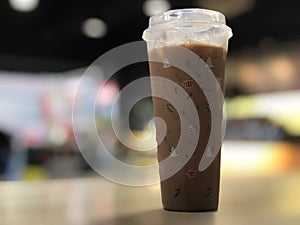 Close-up, iced coffee on a wooden table in the shop. Coffee cup with christmas icon. Copy space on right for design or text.