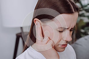 Close up of ill upset young caucasian woman have ear pain or earache, female suffering painful otitis from loud or noisy sound,