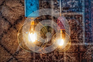 Close-up of illuminated light bulbs hanging against wall