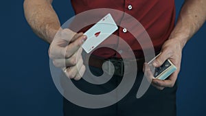 Close up illusionist in red shirt showing playing cards magic focuses