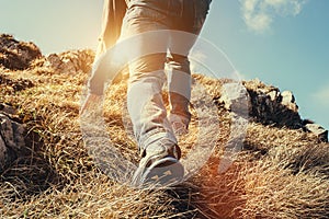 Close up imade climber legs make a last steps before peak