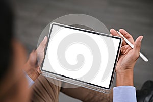 Close-up image of an Asian man using his digital tablet in a room. tablet white screen mockup