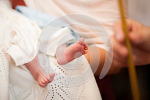 Close-up image of babys feet on white blanket in church