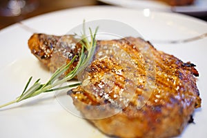 Close up image of beef steak with twig of rosemary