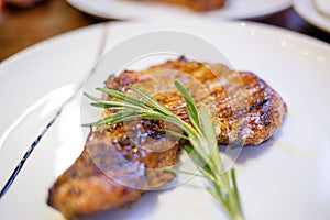 Close up image of beef steak with twig of rosemary