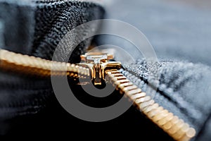 Close up image of a black denim jeans with its metal zipper or fly open and zipper tape metallic puller, bridge, slider