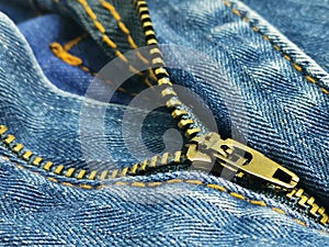 Close up image of blue jeans fabric zipper.