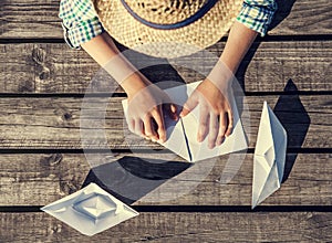 Close up image boy hands making a paper boats