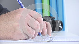 Close Up Image with a Businessman at Workplace Taking Notes