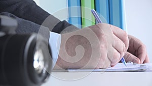 Close Up Image with a Businessman at Workplace Taking Notes