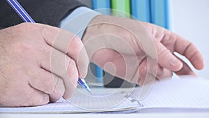 Close Up Image with a Businessman at Workplace Taking Notes