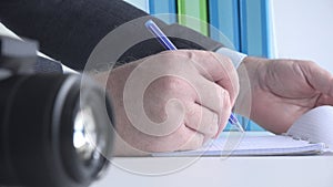 Close Up Image with a Businessman at Workplace Taking Notes