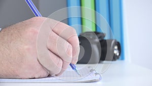 Close Up Image with a Businessman at Workplace Taking Notes