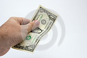 An a close up image of a Caucasian male hand holding a one DollarUSA note with a plain background.