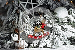 Close-up image of Christmas festive decoration with garlands, reindeer toy, white shine balls and wood stars.