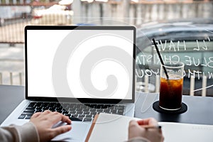 A close-up image of a college student studying online on her laptop computer at a coffee shop