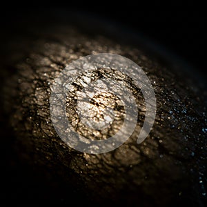 Close-up image of a cracked, textured surface with an intricate, web-like pattern. The